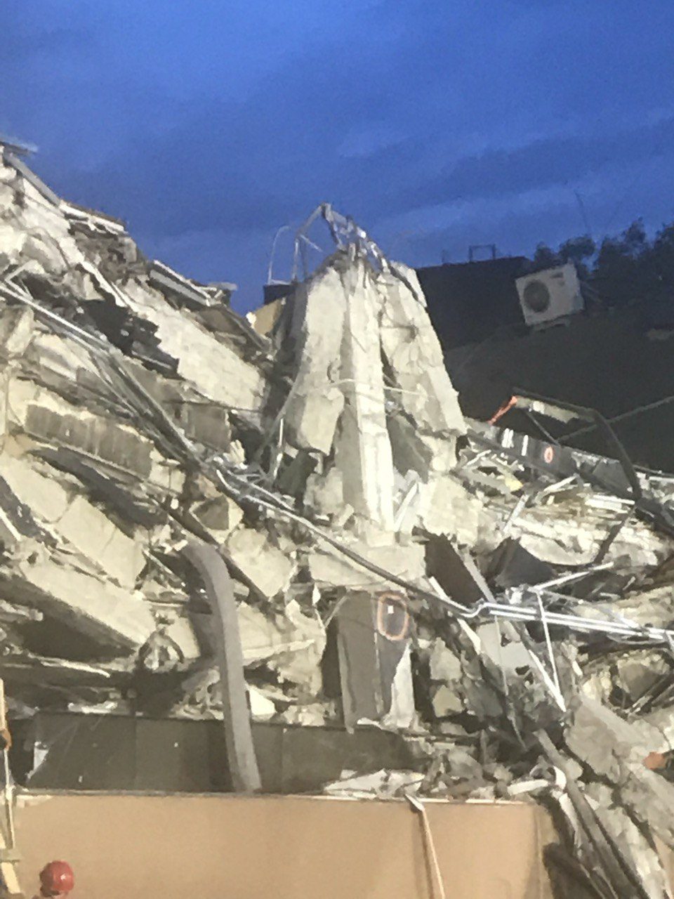 Close detail of collapsed concrete slabs and twisted reinforcement at a building base, Mexico City 2017.